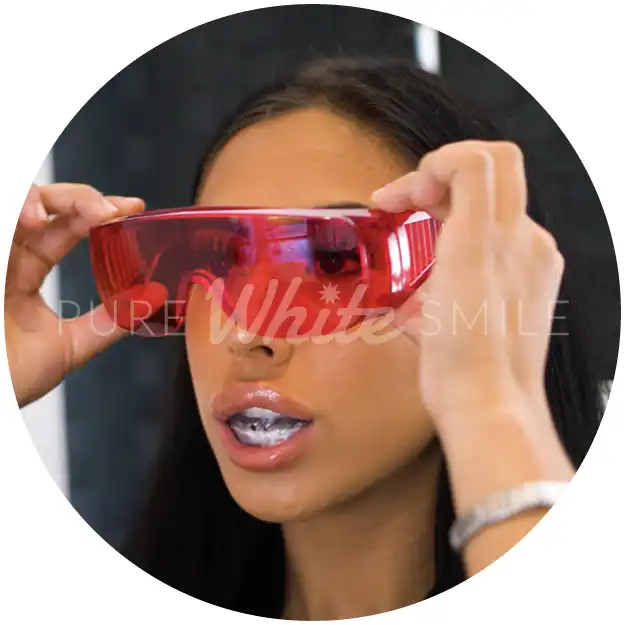 A client putting on protective safety glasses as part of step 5 before the Naturawhite Diamond Light 80W laser is activated to begin the laser teeth whitening process at Pure White Smile in Chorley.
